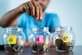 Focus on jar, Man from behind placing coins inside the jar - Concept of monthly SIP or systematic investment plan Royalty Free Stock Photo