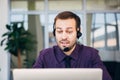 Focus on a joyful call centre agent with his headset Royalty Free Stock Photo