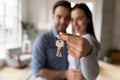 Focus on keys, held by excited young homeowners. Royalty Free Stock Photo