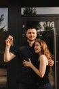 Focus on keys, held by excited young spouses homeowners. Happy married family couple celebrating moving in new house home , Royalty Free Stock Photo