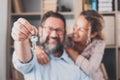 Focus on keys, held by excited young spouses homeowners. Happy married family couple celebrating moving in new house home , Royalty Free Stock Photo