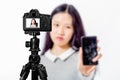 Focus on live view on camera on tripod, teenage girl   with blurred scene in background. Teenage vlogger livestreaming show Royalty Free Stock Photo