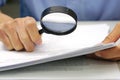 Focus magnifying glass, Hand of businessperson looking at documents through magnifying glass. Royalty Free Stock Photo