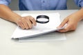 Focus magnifying glass, Hand of businessperson looking at documents through magnifying glass. Royalty Free Stock Photo