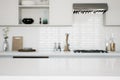 Focus on the marble countertop against the backdrop of kitchen appliances and utensils.