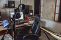 Microphone and headphones in blurred sound engineer office for broadcasting and music rehearsal space. Recording studio