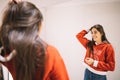 On focus mirror reflection of woman with Christmas blouse