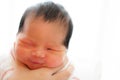 Focus on mother is mom holding asian newborn baby`s head in her hands for belch after breastfeeding Royalty Free Stock Photo