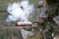 Focus on old stone wall; traditional steam train and carriages in background Royalty Free Stock Photo