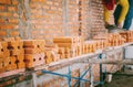 Focus on the orange bricks within the construction site where construction workers are working. The orange bricks are stacked and Royalty Free Stock Photo