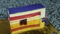 Focus out from piece of violet glazed cheesecake with red berry jelly interlayer