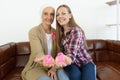 Focus at the pink cancer ribbon on hand of young woman and senior breast cancer patient