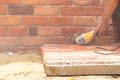 Focus on the polyurethane foam Brick wall on the floor with blur worker hand and grinder machine behind Royalty Free Stock Photo