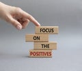 Focus on the Positives symbol. Concept word Focus on the Positives on wooden blocks. Beautiful grey background. Businessman hand. Royalty Free Stock Photo