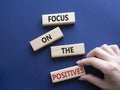 Focus on the Positives symbol. Concept words Focus on the Positives on wooden blocks. Beautiful deep blue background. Businessman