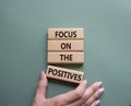 Focus on the Positives symbol. Concept words Focus on the Positives on wooden blocks. Beautiful grey green background. Businessman Royalty Free Stock Photo