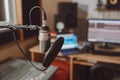 Focus on a professional microphone on the blurred workplace of a sound engineer in music recording studio Royalty Free Stock Photo