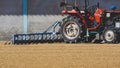 Red tractor is parked on grain paddy rice drying courtyard inside of rice mill area Royalty Free Stock Photo