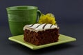 Focus on red velvet cake on green plate with mug and yellow flow