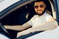 Front view, young handsome man looking straight while driving a car Royalty Free Stock Photo