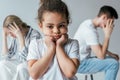 Focus of sad african american kid touching face near divorced foster parents isolated on grey