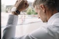 Focus of sad businessman standing with clenched fist near window Royalty Free Stock Photo