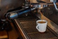 Picture Focus selection: Coffee flows from a professional coffee maker with a deep filter on a white cup