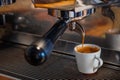 Focus selection: Coffee flows from a professional coffee maker with a deep filter on a white cu