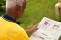 Focus on shoulder, Shoulder shot of old man busy reading morning news paper - Concept of senior people morning daily