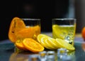 focus at slice orange and lemon, between juice glass and ice on table Royalty Free Stock Photo