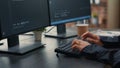 Focus on software developer hands typing source code on keyboard while looking at computer screen Royalty Free Stock Photo