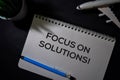 Focus On Solutions! write on a book isolated on Office Desk