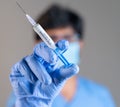 Focus on syringe, close up of doctor or nurse hands holding covid vaccination booster shot or 3rd dose syringe