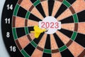 focus on tip, Close handheld shot of hands throwing dirt tip on 2023 dirt board - concept of target new year 2023