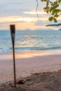 Focus on the torch on the sandy beach of Thailand and the sunset Royalty Free Stock Photo