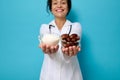 Focus on transparent glass bowls with ripe sweet dates and unhealthy white refined sugar on the hands of female doctor