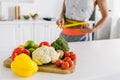 Focus of vegetables on cutting board near woman measuring waist Royalty Free Stock Photo