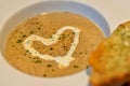 Focus view warm mushroom soup decorated with heart shaped cream