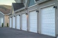 Focus on the white garage doors of townhousesflanked by outdoor wall lamps Royalty Free Stock Photo