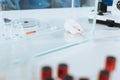 Focus of white mouse in glass box near ampules, syringe and petri dish Royalty Free Stock Photo