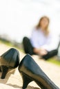 In focus, women`s shoes are on heels, they are in the sand. In the background, there is no focus girl. The horizon line is skewed Royalty Free Stock Photo