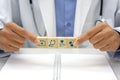 Hand of doctor holding a wooden block cube with healthcare medical icon symbol and below, there is a blurred book placed.