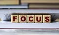 FOCUS - word on wooden cubes against the background of the open book