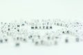 Focus on the word writer among scattered letter blocks on a plain background in a creative workspace setting Royalty Free Stock Photo