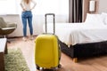 Focus of yellow luggage near woman