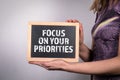 Focus on Your Priorities. Business woman holding a chalk board