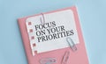 FOCUS ON YOUR PRIORITIES, text on white paper on blue table Royalty Free Stock Photo