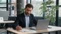 Focused adult businessman work on project in office using laptop writing notes caucasian man business leader Royalty Free Stock Photo