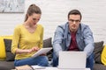 focused adult couple of freelancers working on couch