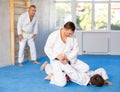 Focused adult jiu-jitsu fighter performing painful armlock during sparring